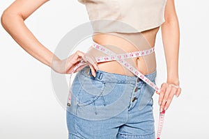 Close Up Woman measuring her waistline with measure line