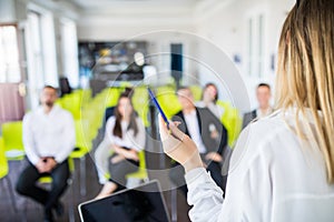 Close up of woman mentor or coach hold paperwork, give flipchart presentation, talking with employees. Businesswoman have