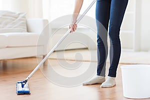 Close up of woman with mop cleaning floor at home