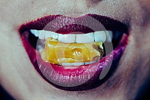 Close-up of woman mouth biting caramel candy