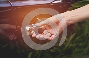 Close-up of woman opening a car door. Hand on handle.