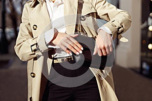 Close up of woman is opening her bag while standing on city street