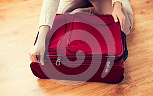 Close up of woman packing travel bag for vacation