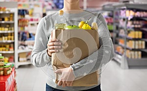 Close up of woman with paper bag full of food photo