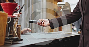 Close-up woman paying using NFC technology with phone contactless payment with student girl, business woman.Pay by phone