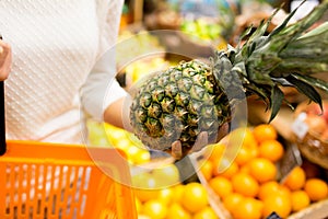 Close up of woman with pineapple in grocery market
