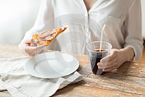 Close up of woman with pizza and coca cola drink