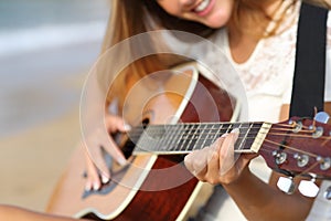 Close up of a woman playing guitar on the beach