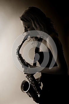 Close-up of woman playing saxophone, sepia toned.