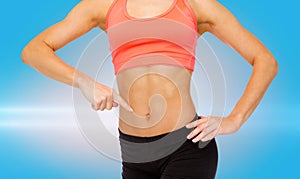 Close up of woman pointing finger at her six pack