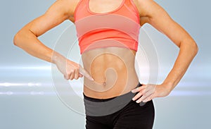 Close up of woman pointing finger at her six pack