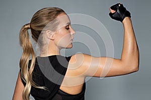 Close up of woman posing and showing biceps in gym