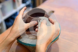 Close up of woman potter hands works with clay and ceramic, craftsman hands. knead and moistens the clay before work in ceramic