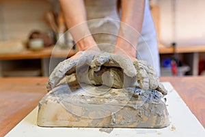 Close up of woman potter hands works with clay and ceramic, craftsman hands. knead and moistens the clay before work in ceramic