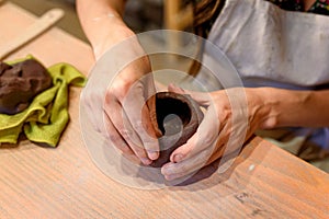 Close up of woman potter hands works with clay and ceramic, craftsman hands. knead and moistens the clay before work in ceramic