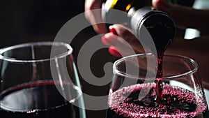 Woman pouring red wine into glass, tasting and degustation