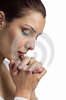 Close-up of woman praying with joining hands and eyes closed