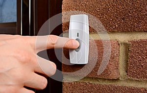 Close-up of woman pressing a doorbell photo