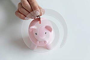 Close up of woman put coin in piggy bank