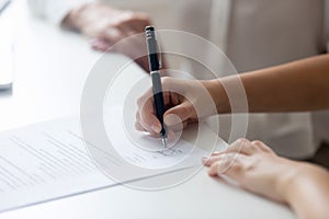 Close up of woman put signature on document or contract