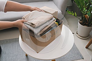 Close-up Of A Woman Putting Clothes Inside Donation Box photo