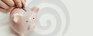 Close up of woman putting a coin inside piggy bank as investment. save money concept