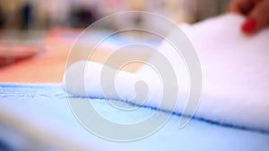 Close-up of woman putting fresh clean towel on bed