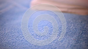 Close-up of woman putting fresh clean towel on bed