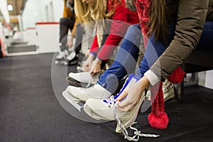 Close up of woman putting on ice skates
