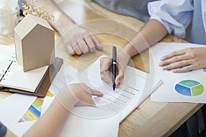 Close up, woman putting signature on document loan contract, real estate purchase, hands of woman sale represent point document to