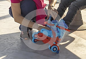 close-up of woman putting skates on child