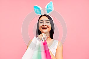 Close-up of a woman in rabbit ears with shopping bags in her hands, spring shopping, a traditional holiday