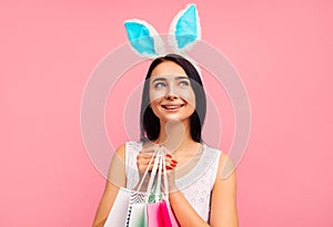 Close-up of a woman in rabbit ears with shopping bags in her hands, spring shopping, a traditional holiday