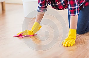 Close up of woman with rag cleaning floor at home