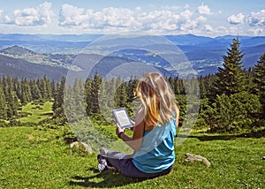 Close-up of woman reading e-book in nature