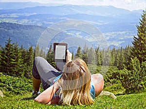 Close-up of woman reading e-book in nature