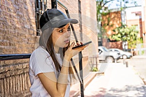 Close up woman recording voice message, speaking, young female holding phone in hand near face, chatting with friends online or