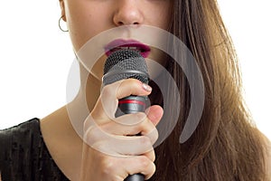 Close up of woman with red lips hold a microphone at her mouth