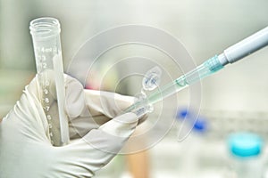 Close up of the woman researcher using pipette to transfer resuspension of cells line from 15 ml tube to micro tube 1.5 ml in the