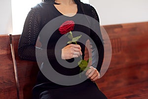 Close up of woman with roses at funeral in church