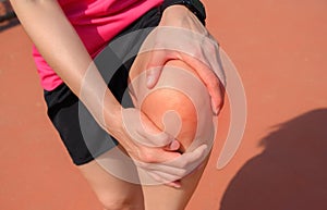 Close up of woman runner suffering from knee pain. It often happens when your kneecap is out of alignment.