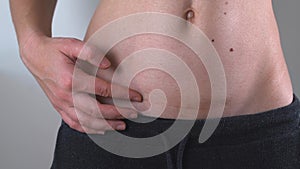 Close up of woman`s belly with cesarean scar. Postpartum recovery. Baby delivery operation. Fit woman after birth