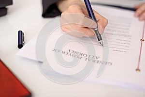 Close-up of a woman's hand filling a power of attorney