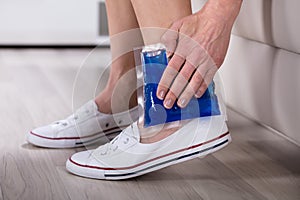 Person Applying Ice Bag On Ankle photo