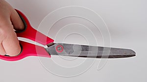 Close-up of woman`s hand holding scissors, getting ready to cut, white background, concept of splitting, starting a new business