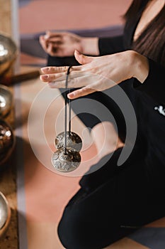 Close-up of a woman& x27;s hand holding Tibetan bells for sound therapy. Tibetan cymbals