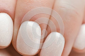 Close-up of woman`s hand. manicure. Closeup top view of elegant pastel pink natural manicure. cuticle removal with a