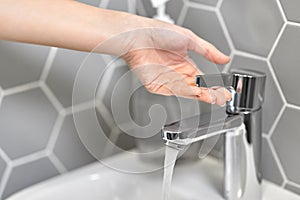 Close up of woman`s hand opening water tap