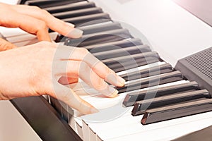 Close up of woman`s hand playing digital piano