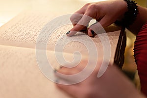 close-up of a woman's hand reading a braille book